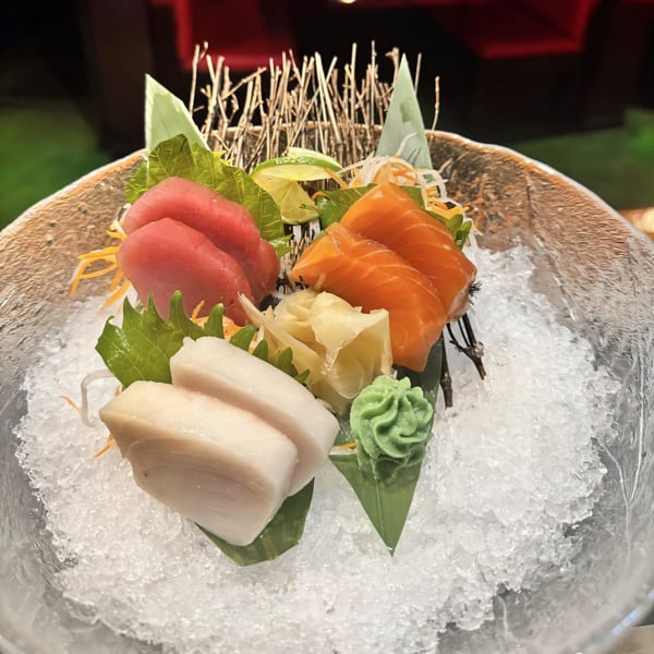 Agami Sushi's sashimi platter with tuna, salmon, and white fish, served on ice with ginger and wasabi.